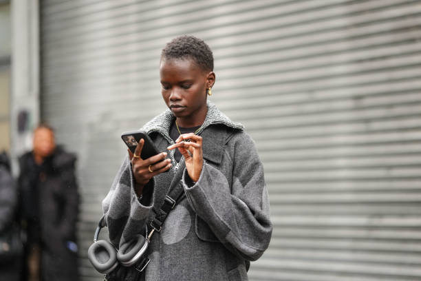 Model wears gold earrings, gold necklace, dark gray light gray polka dotted wool coat, outside Brandon Maxwell, during the New York Fashion week...