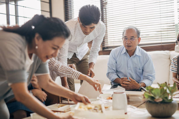 modern family eating take-out food together - junk food stock pictures, royalty-free photos & images