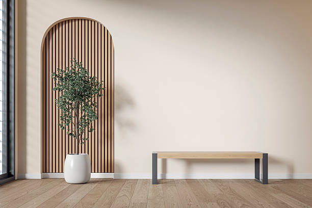 modern interior: an unfurnished living/waiting room with a modern bench, a potted plant (ficus) in front of a partly textured light beige (cream) neutral wall, partly arched paneled light pink wooden slat, large window and de