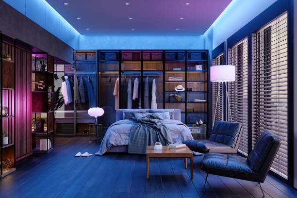 modern slaapkamerinterieur 's nachts met neonlicht. rommelig bed, kleding in kast, fauteuils en vloerlamp. - home decoration stockfoto's en -beelden