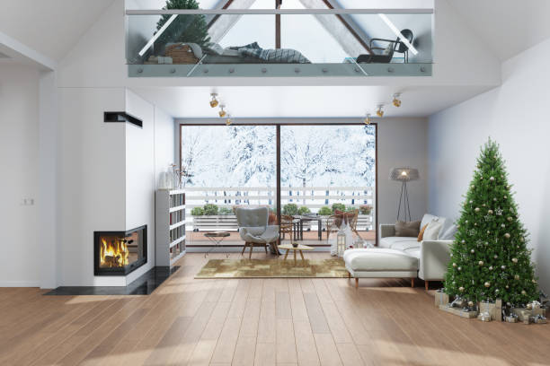 modern villa interior with christmas tree, gift boxes, fireplace, sofa and snowy garden view through the window. attic bedroom decorated for christmas - garden decoration stock pictures, royalty-free photos & images
