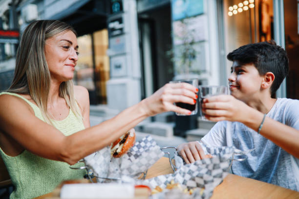 mom taking her kid to the burger place - junk food stock pictures, royalty-free photos & images