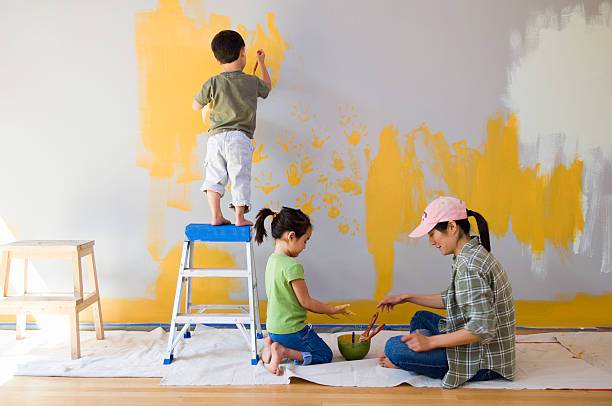mother and children (2-6) painting living room wall - home decoration stock pictures, royalty-free photos & images