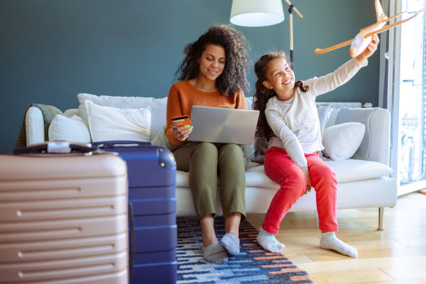 mother and daughter choosing their next vacation destination - travel stock pictures, royalty-free photos & images