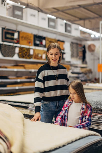 mother and daughter enjoy shopping and furnishing a new apartment together, choosing carpets - home decoration stock pictures, royalty-free photos & images