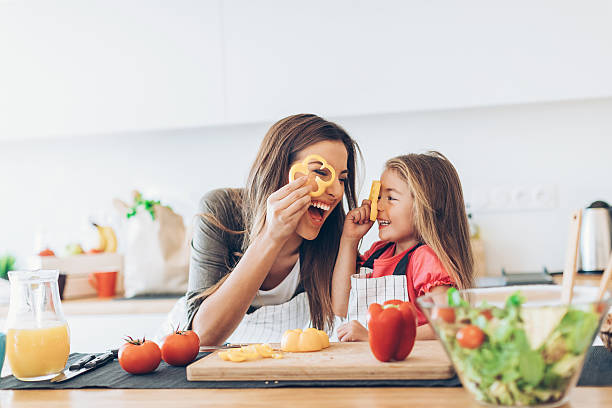 mother and daughter having fun with the vegetables - food stock pictures, royalty-free photos & images