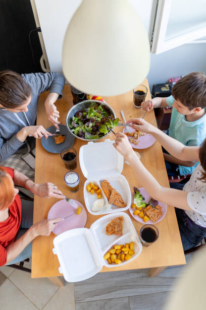 mother and her children at the table eating fast food delivered - junk food stock pictures, royalty-free photos & images
