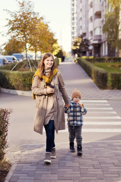 mother and son walking city street - junk food stock pictures, royalty-free photos & images