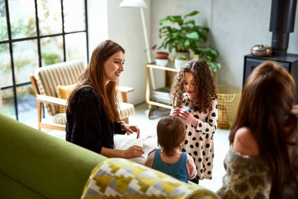 mother sitting on sofa at home with children - home decoration stock pictures, royalty-free photos & images