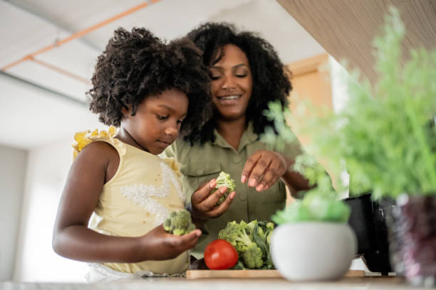mother teaching daughter how to prepare vegetables - food stock pictures, royalty-free photos & images