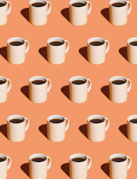 mugs of black coffee in rows against peach background - coffee stock pictures, royalty-free photos & images