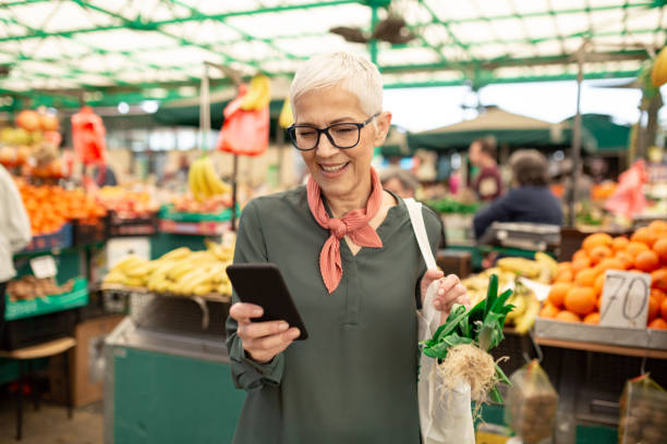 mujer mayor comprando en el mercado de agricultores - food fotografías e imágenes de stock