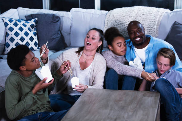 multi-ethnic blended family eating chinese take out food - junk food stock pictures, royalty-free photos & images