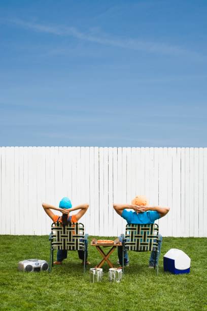 multi-ethnic couple looking at newly painted fence - garden decoration stock pictures, royalty-free photos & images