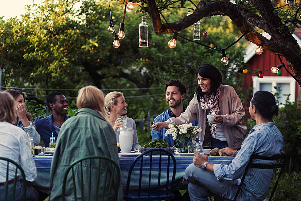 multi-ethnic friends enjoying dinner party at yard - garden decoration stock pictures, royalty-free photos & images