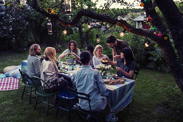 multi-ethnic friends having food at dining table in yard - garden decoration stock pictures, royalty-free photos & images