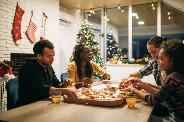 multi-ethnic group of friends enjoying pizza together - junk food stock pictures, royalty-free photos & images