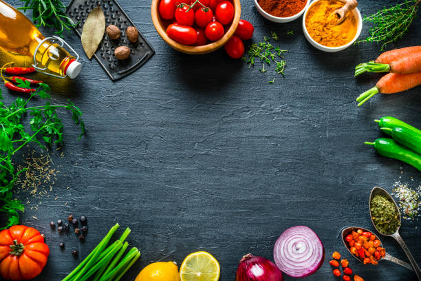 multi colored vegetables and spices frame on black slate background. overhead view - food stock pictures, royalty-free photos & images