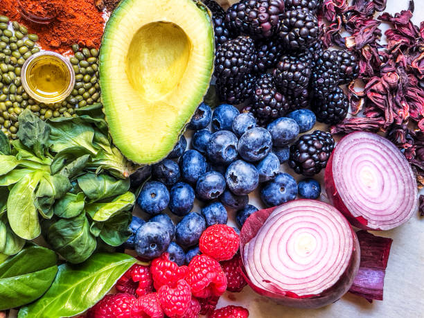 multi colored vegetables, fruits and legumes on wooden table - food stockfoto's en -beelden