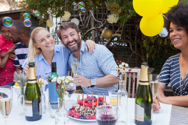 multi generation family enjoying birthday party at garden patio table - garden decoration stock pictures, royalty-free photos & images