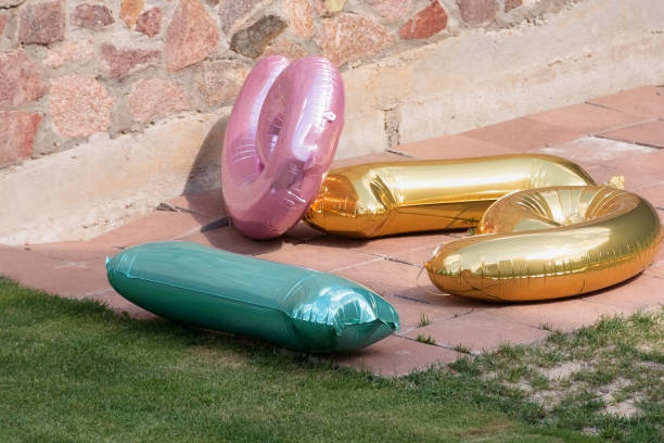 multicolored number balloons lie in backyard - garden decoration stock pictures, royalty-free photos & images