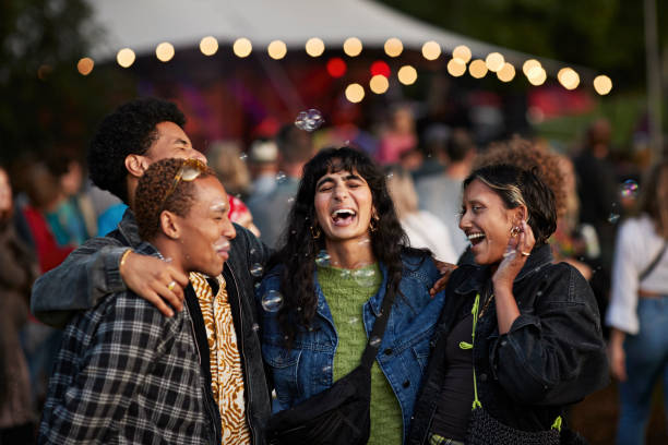 multiracial friends laughing amidst bubbles - concert stock pictures, royalty-free photos & images