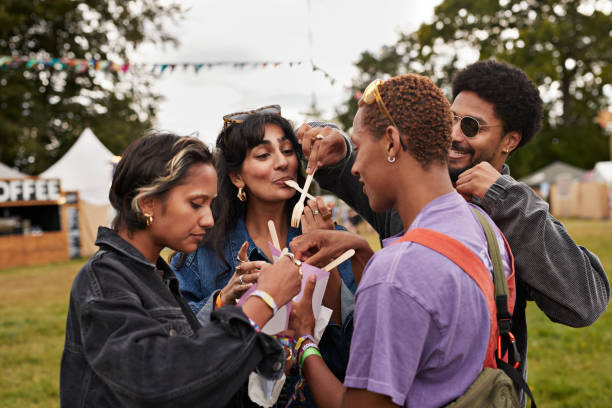 multiracial friends sharing dessert at concert - concert stock pictures, royalty-free photos & images