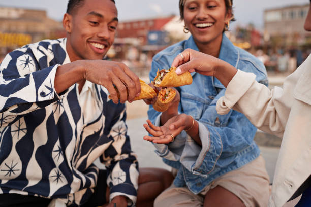 multiracial friends toasting tacos on promenade - food stock pictures, royalty-free photos & images