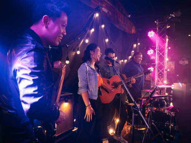 music band performing on stage in night club. - concert stock pictures, royalty-free photos & images
