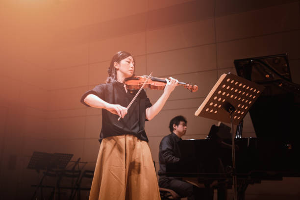 musicians playing violin and piano at classical music concert - concert stock pictures, royalty-free photos & images