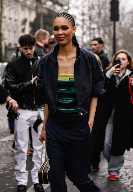 Nara Smith is seen wearing a black jacket, striped Miu Miu shirt, black pants and brown and white bag outside the Miu Miu show during the Womenswear...
