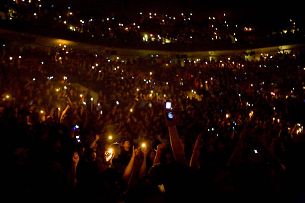 Near sold out crowd of heavy metal fans hold up cell phones and lighters during a Metallica show at the Rose Garden arena in Portland. The band is on...