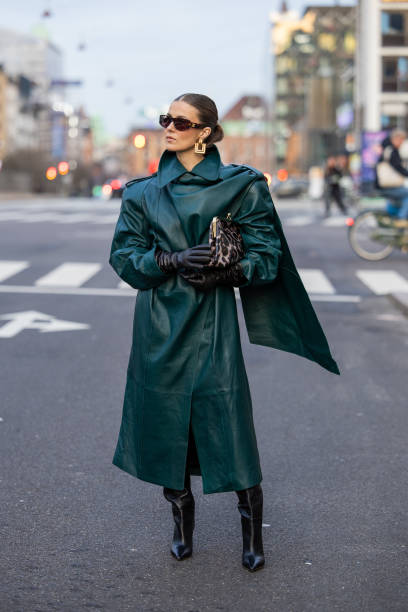 Nina Sandbech wears Celine sunglasses, black gloves, green leather coat, black boots, bag with leopard print, earrings on her way to Forza Collective...
