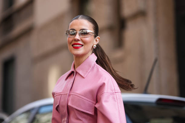 Nina Sandbech wears silver glasses, silver earrings, a pink oversized jacket, outside Sportmax, during the Milan Fashion Week Womenswear Fall/Winter...