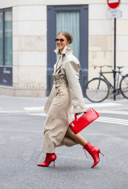 Nina Sandbech wears trench jacket and beige skirt Helsa, red ankle boots shoes Jimmy Choo, red bag Ferragamo, sunglasses Loewe, earrings, golden...