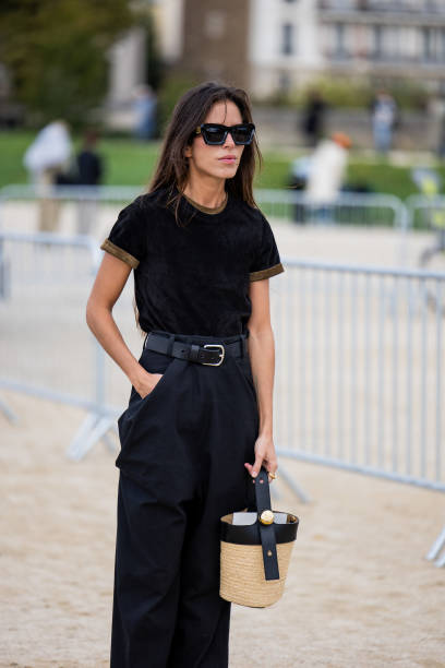 Nina Urgell Cloquell wears black shirt, high waisted pants, basket bag, sunglasses outside Loewe during Womenswear Spring/Summer 2025 as part of...