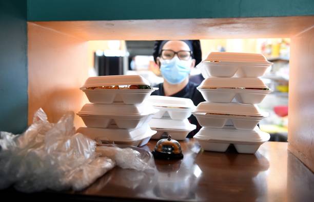 Nov. 21, 2020 -- A kitchen staff member arranges lunch boxes with food for take-away meals at a bar during the COVID-19 pandemic in Ogre, Latvia,...