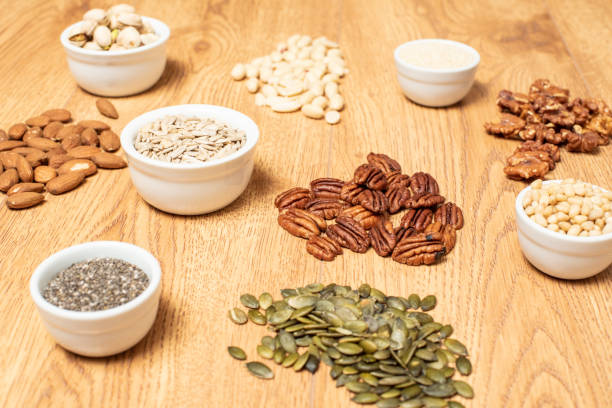 nuts and seeds on a table - food stock pictures, royalty-free photos & images