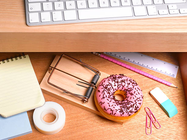 obesity issues doughnut hidden in desk drawer - junk food stockfoto's en -beelden