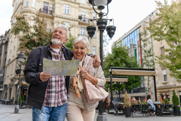 older travelers are sightseeing the city during a vacation using a city map. - travel stock pictures, royalty-free photos & images