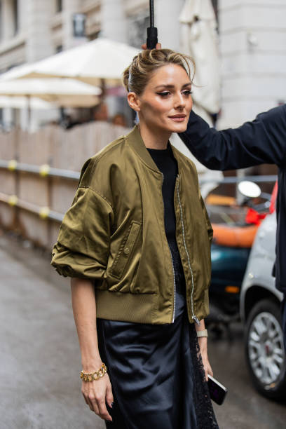 Olivia Palermo wears black laced dress, green bomber jacket outside Del Core during the Milan Fashion Week Menswear Spring/Summer 2025 on September...