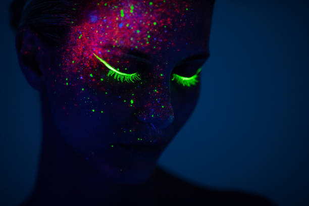 one woman painted with fluorescent make up - fashion stock pictures, royalty-free photos & images