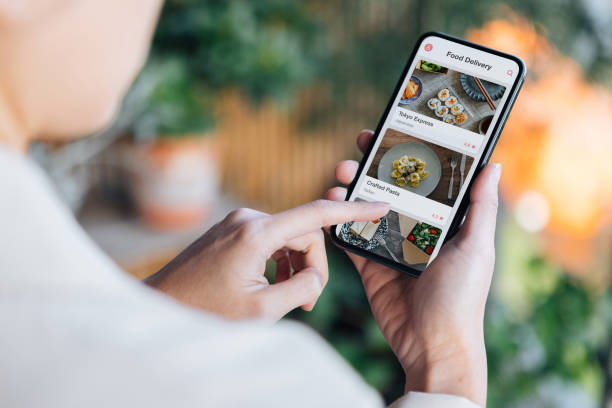 ordering food online at home with smartphone - junk food stock pictures, royalty-free photos & images