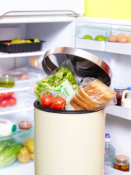 out of date food in garbage bin in-front fridge - food stock pictures, royalty-free photos & images