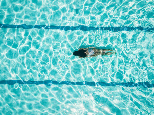 overhead view on girl idiving in swimming pool - fashion stock pictures, royalty-free photos & images
