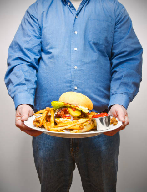overweight man holding a very large plate of fried food - junk food stock pictures, royalty-free photos & images