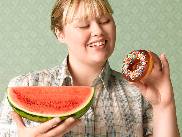 overweight teenage girl with water melon - junk food stockfoto's en -beelden