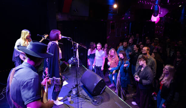 packed crowd at small venue watching band perform on stage - concert stock pictures, royalty-free photos & images