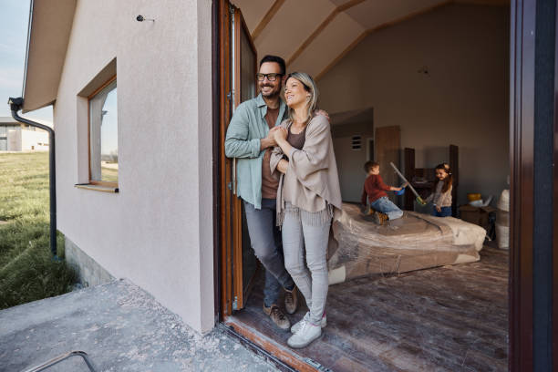 padres felices disfrutando en la puerta de su nuevo hogar. - home decoration fotografías e imágenes de stock
