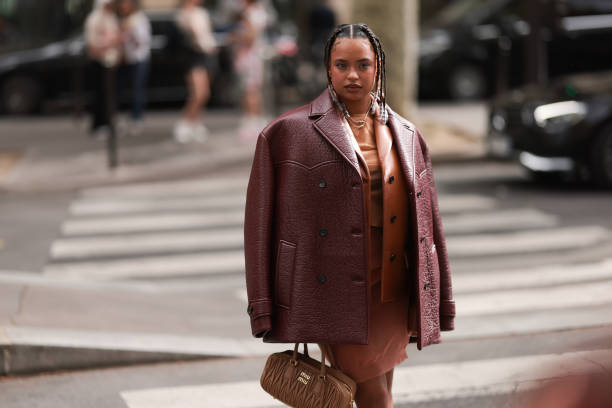 Paola Locatelli is seen wearing a cognac leather jacket, a red-brown oversized leather jacket, an orange dress and a brown Arcadie Miu Miu handbag...